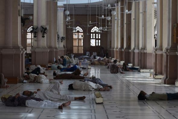 Los eternos problemas de suministro de electricidad de Pakistán se han notado estos días con numerosos cortes. Paquistaníes musulmanes buscan frescura en el piso de la mezquita.