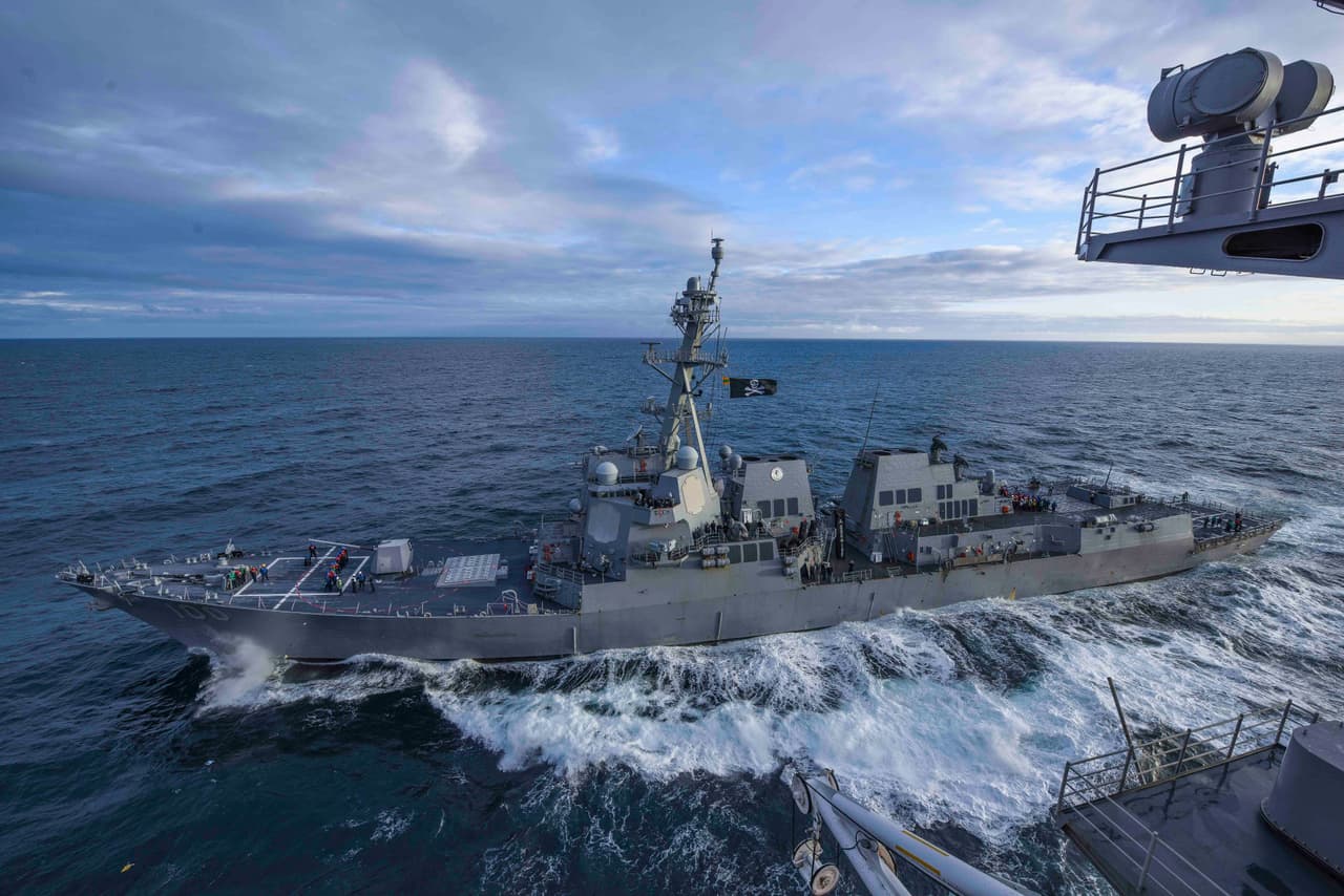 El destructor USS Kidd (DDG 100) pasa junto al portaviones USS Theodore Roosevel en un ejercicio en el Pacífico, en 2019.