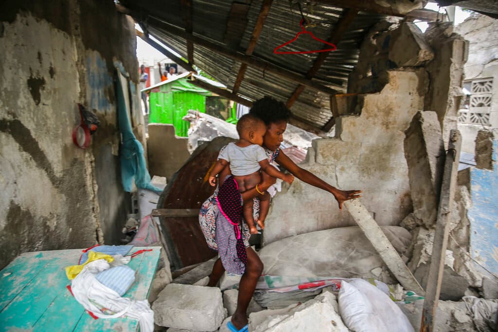 Una mujer con su bebé en lo que quedó de su vivienda en Les Cayes. La zona con algunos de los daños más significativos fue el centro de la ciudad Jeremie, donde viven unas 200,000 personas y que está conformada mayormente por construcciones de un solo piso.