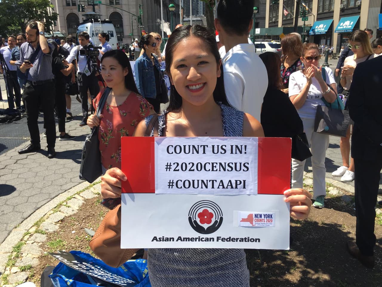 Una seguidora de la Federación Asiático-Americana mostrando su apoyo con una pancarta frente a Foley Square.