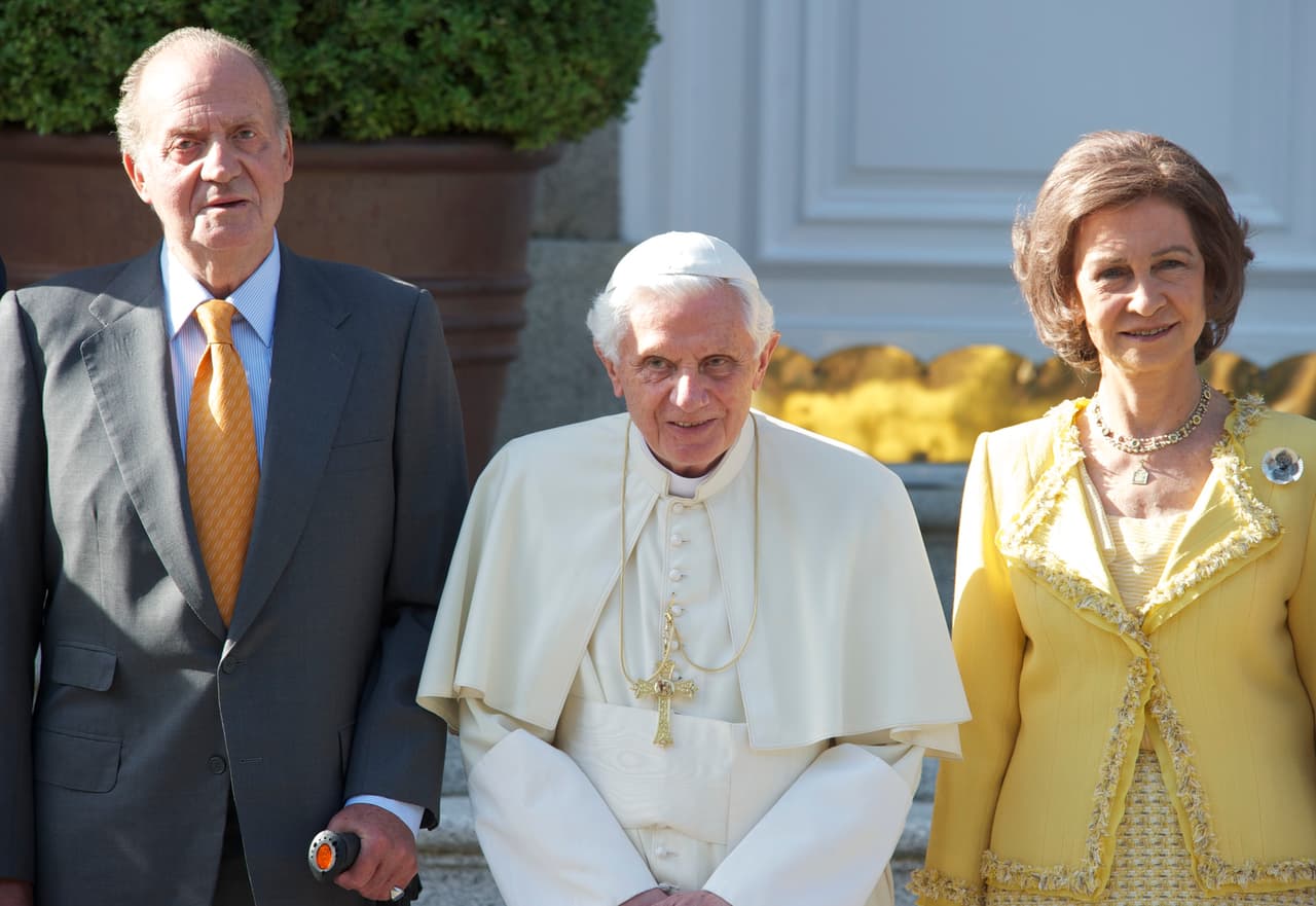 El rey emérito de España, Juan Carlos, y su esposa, la reina Sofía, reciben a Benedicto XVI en Madrid el 19 de agosto de 2011, donde encabezó las Jornadas Mundiales de la Juventud, un encuentro iniciado por su antecesor, Juan Pablo II, en 1985 y que se celebra cada tres años en distintos países. Juan Carlos 
<a href="https://www.univision.com/noticias/mundo/en-medio-de-sospechas-de-corrupcion-el-rey-emerito-juan-carlos-i-anuncia-que-se-va-de-espana" target="_blank">abandonó España en 2020 en medio de acusaciones de corrupción</a>.