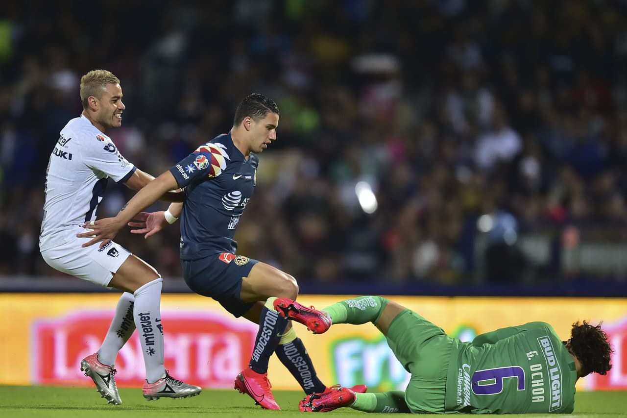 Guillermo Ochoa juega muy bien su área y se queda con la pelota.