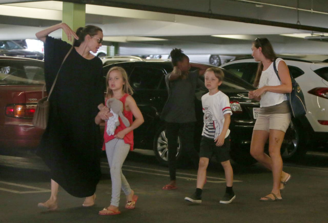 Angelina terminando sus compras con tres de sus hijos.