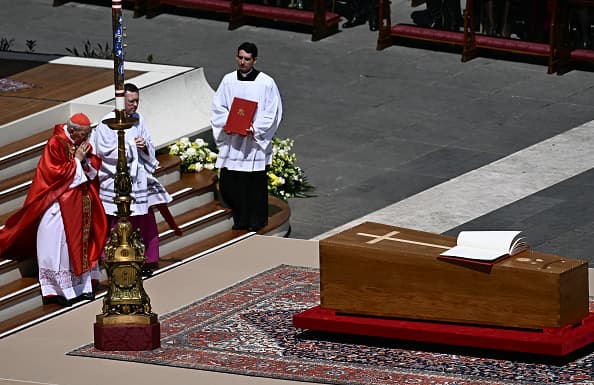 El cardenal decano Giovanni Battista Re ora frente al ataúd del papa en la plaza de San Pedro.