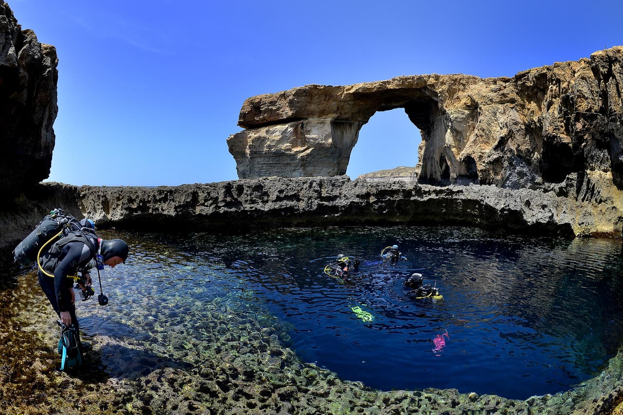 DWEJRA, GOZO - MAY 20: Divers are seen in front of the natural arch 'The Azure Window' at Dwejra Bay on May 20, 2014 in Dwejra/Gozo, Malta. (Photo by Sascha Steinbach/Getty Images)