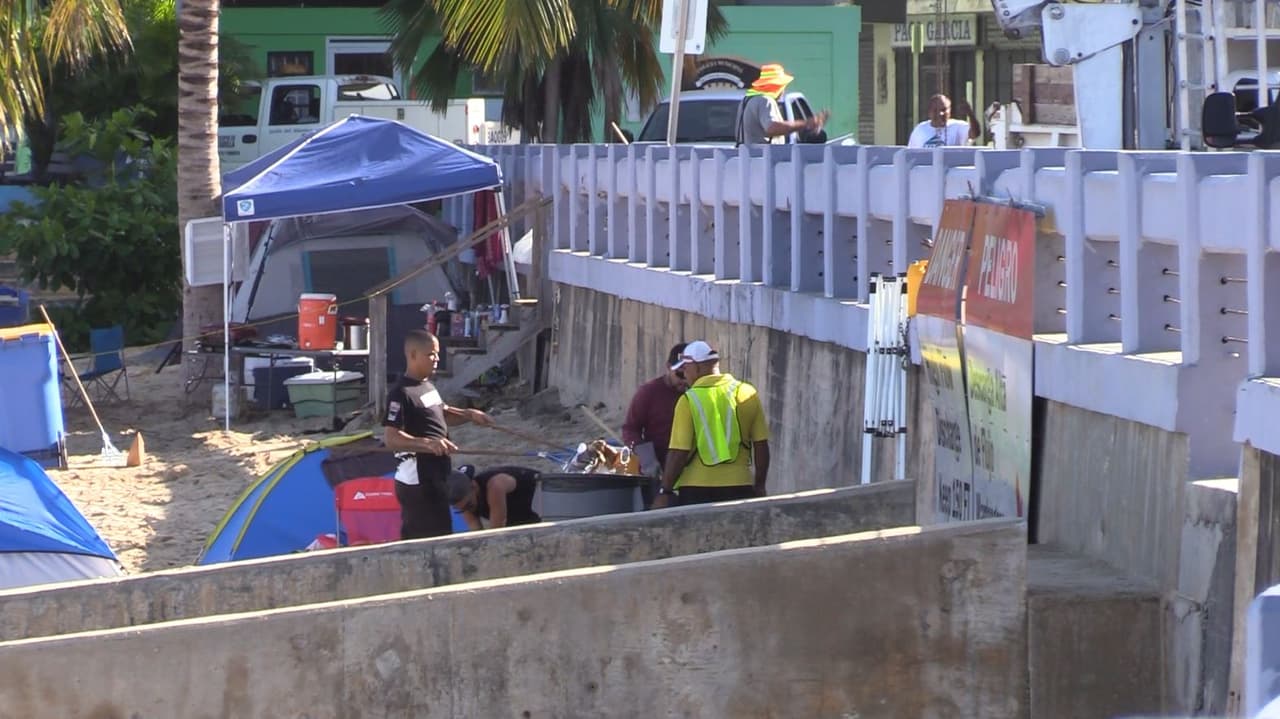 Empleados de Aguadilla realizan labores de limpieza en la playa Rompeolas.