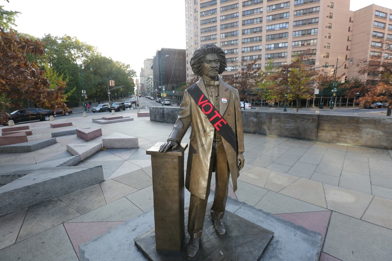 La estatua del abolicionista Frederick Douglas localizada en la esquina de bulevar Fedrerick Douglas y la calle 110 Oeste en Manhattan. Está mañana se vió adornada con un calcomanía que dice "vota" y bandana.