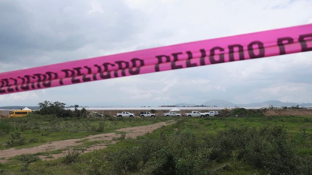 Una cinta de advertencia de peligro se extiende a lo largo de un rancho de Nextipac donde, según los fiscales, se descubrieron cadáveres en una fosa común durante excavaciones para construcción, en el municipio de Zapopan, estado de Jalisco, México, el viernes 11 de julio de 2025.