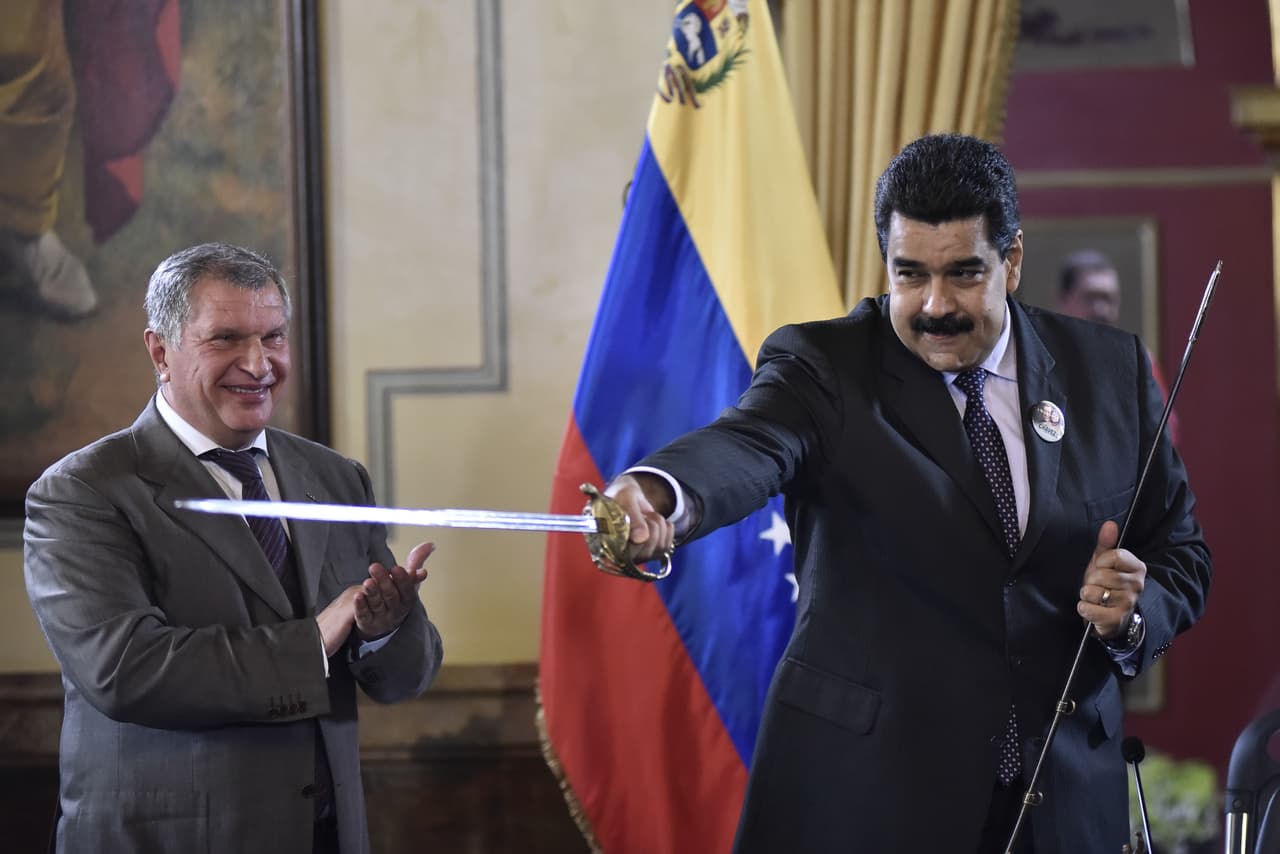 Nicolás Maduro juega con una espada que le dio de regalo Igor Sechin, presidente de la petrolera rusa Rosneft (der) en el Palacio de Miraflores, julio 2016.
