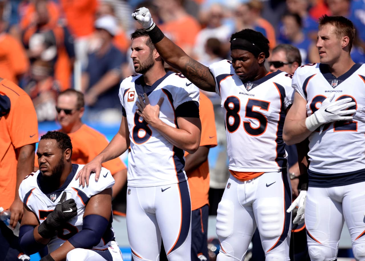 Los jugadores de los Denver Broncos, Virgil Green y Max García de rodillas durante el himno nacional, antes del comienzo del partido contra los Buffalo Bills en Orchard Park, NY.
<br>