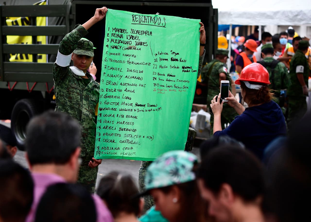 Un soldado muestra una lista de rescatados informal, cerca de uno de los edificios colapsados en la capital.