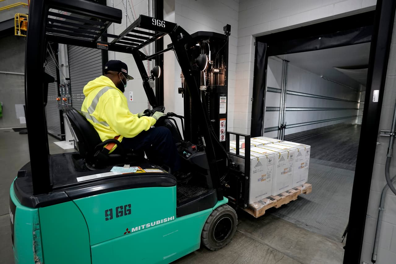 Un trabajador traslada un cargamento de cajas de vacunas en un montacargas hacia el interior de un camión, que saldrá este domingo hacia uno de los más de 600 centros de distribución de todo el país.