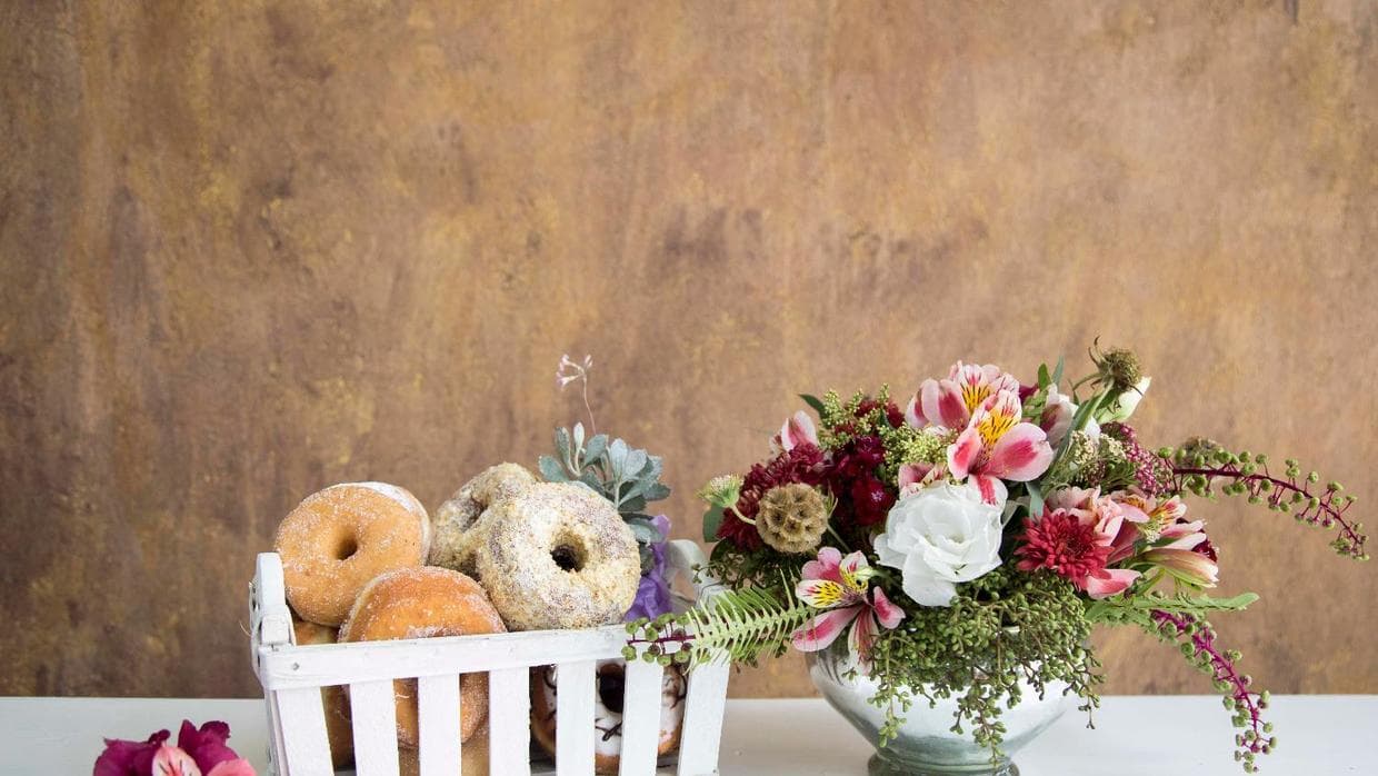 Sin perder de vista que la decoración de tu barra de donas puede (debe) combinarse con la del resto de la boda, puedes acomodarlas en canastas o si lo prefieres en bolsas individuales. Sólo evita usar bolsas de papel pues se manchan y estropean con la grasa. Puedes encontrar buenas ideas 
<b><a href="https://www.theknot.com/content/national-doughnut-day ">en The Knot</a></b>.