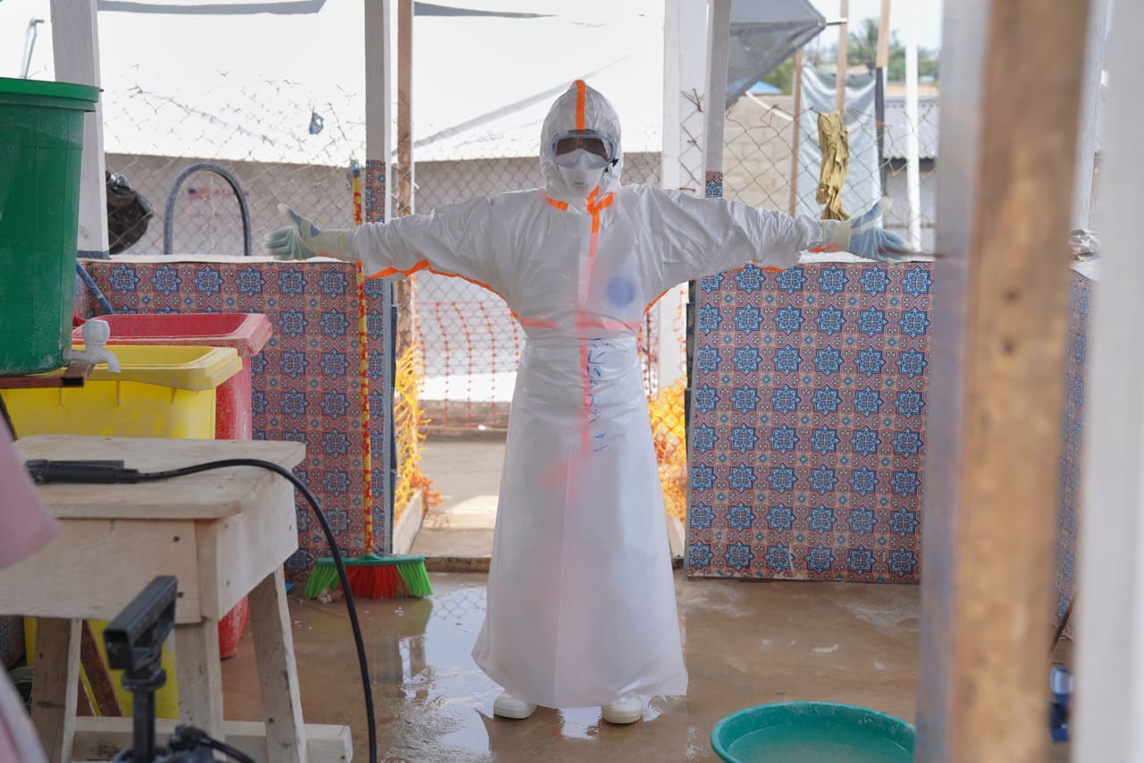 También en los hospitales se realizan desinfecciones constantes. Un trabajador sanitario espera a ser rociado con desinfectante en el centro de tratamiento del Hospital General de Bunia, en Ituri (este del Congo). (Foto AP/Dieudonne Dirole)
