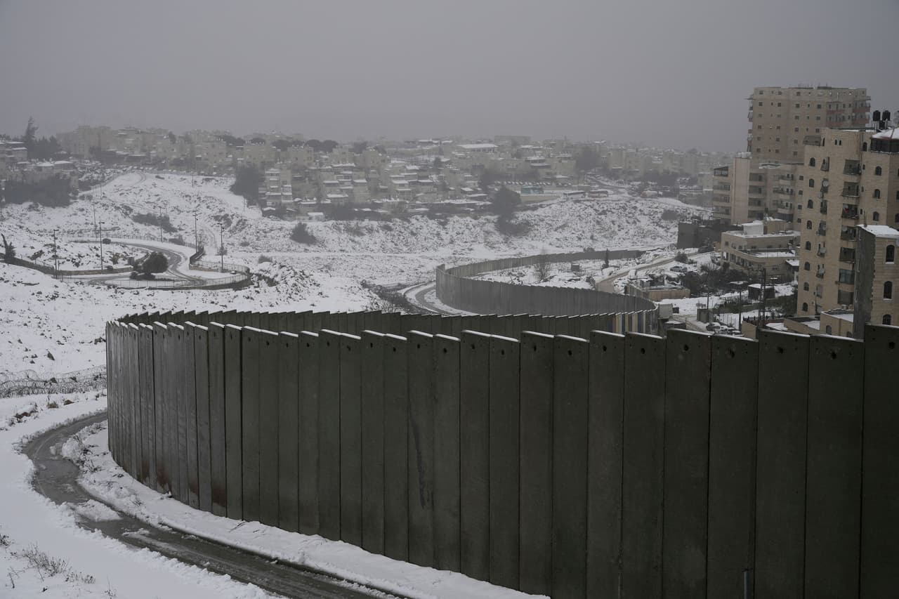La nieve rodea la barrera de separación entre el campo de refugiados de Shuafat, a la derecha, y el barrio de Pisgat Zeev, en el este de Jerusalén.
<br>