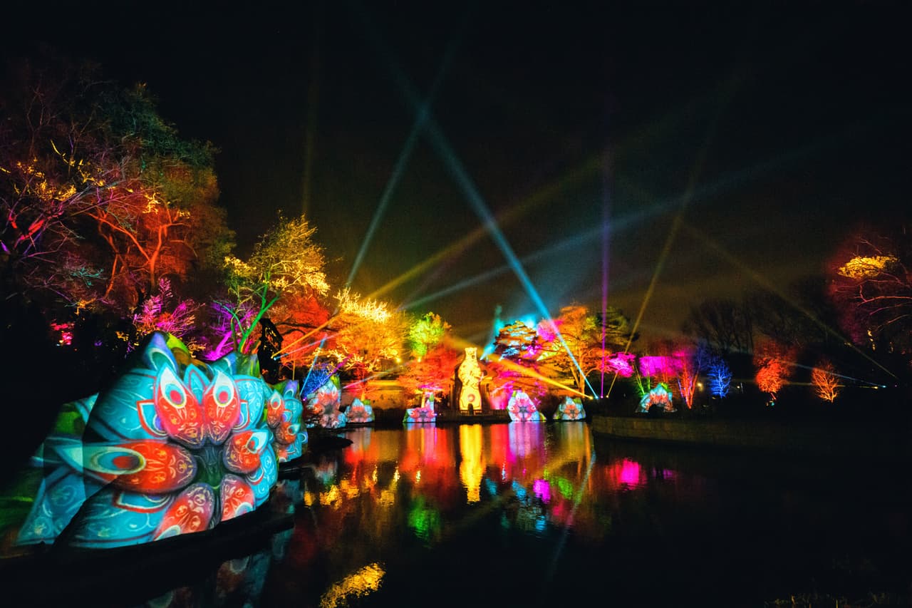 Un caleidoscopio de color llena esta festiva plaza que invita a los huéspedes a comprar sus artículos de iluminación favoritos en la primera barra luminosa del zoológico.