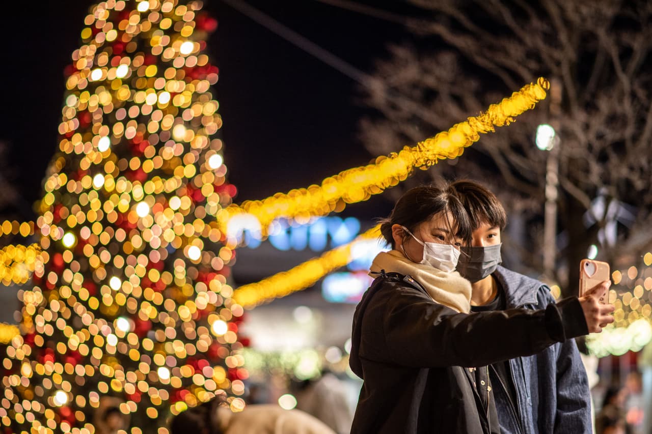 A las afueras de un centro comercial en Saitama, Japón, la gente posaba en frente de las decoraciones navideñas este 25 de diciembre.