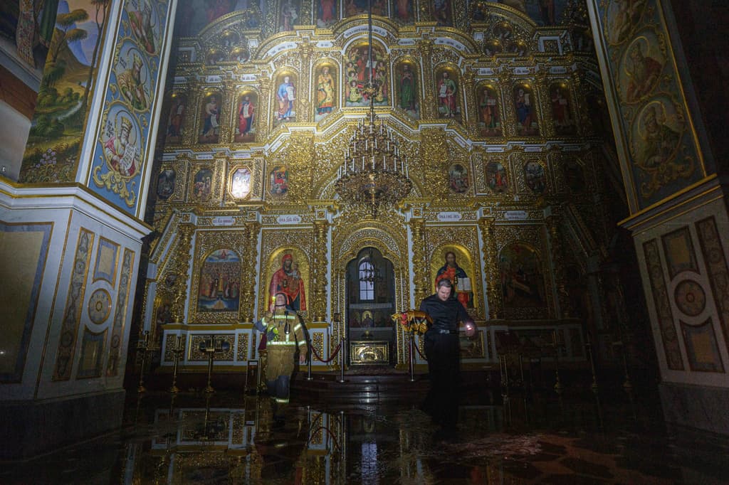Un sacerdote saca objetos de la iglesia de la catedral de la Dormición de la Lavra de Kiev-Pechersk, también conocida como el Monasterio de las Cuevas, mientras arde tras un ataque ruso contra Kiev, Ucrania, el lunes 15 de junio de 2026.