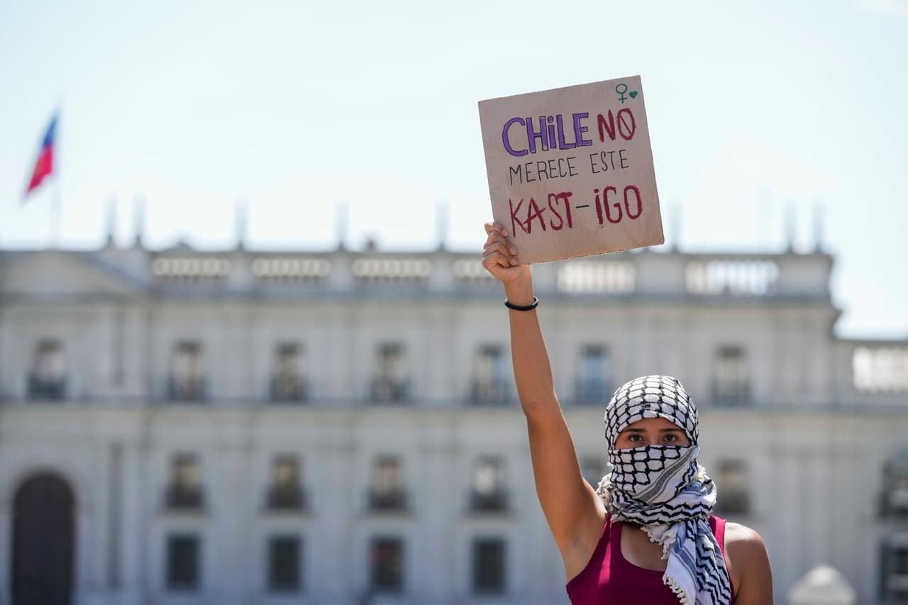 Una mujer sostiene una pancarta en la que se lee en español "Chile no se merece este castigo", un juego de palabras en referencia al presidente electo de Chile, José Antonio Kast, durante una protesta con motivo del Día Internacional de la Mujer en Santiago de Chile, el domingo 8 de marzo de 2026. (Foto AP/Esteban Félix)