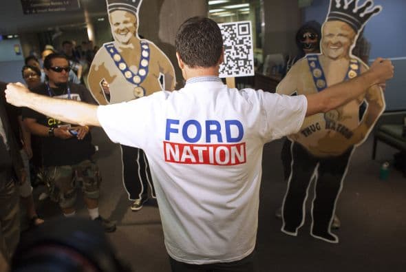 Un partidario Rob Ford muestra su camiseta, mientras que el alcalde de Toronto Rob Ford aborda los medios de comunicación en su primer día de vuelta al trabajo después de participar en un programa de rehabilitación.