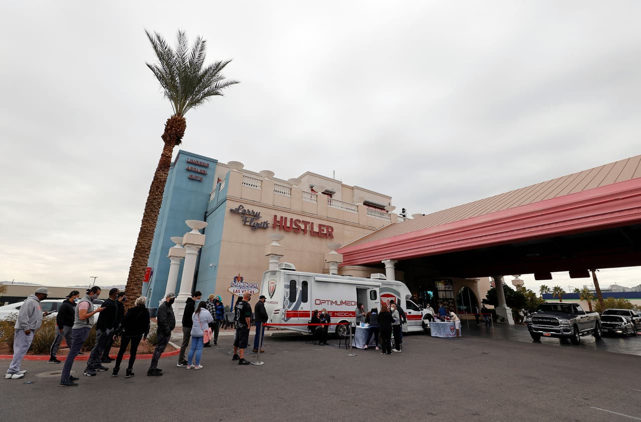 Filas en un centro de vacunación en el club Hustler de Las Vegas, Nevada, el 21 de diciembre. Con el aumento del número de contagios por ómicron, este club de adultos se asoció con la organización
<i>Immunize Nevada</i> para impulsar un evento de vacunación.
<br>
<br>Los que recibieron la inmunización de refuerzo en el lugar fueron compensados con tarjetas de regalo de 200 dólares para gastar en el club.
<br>