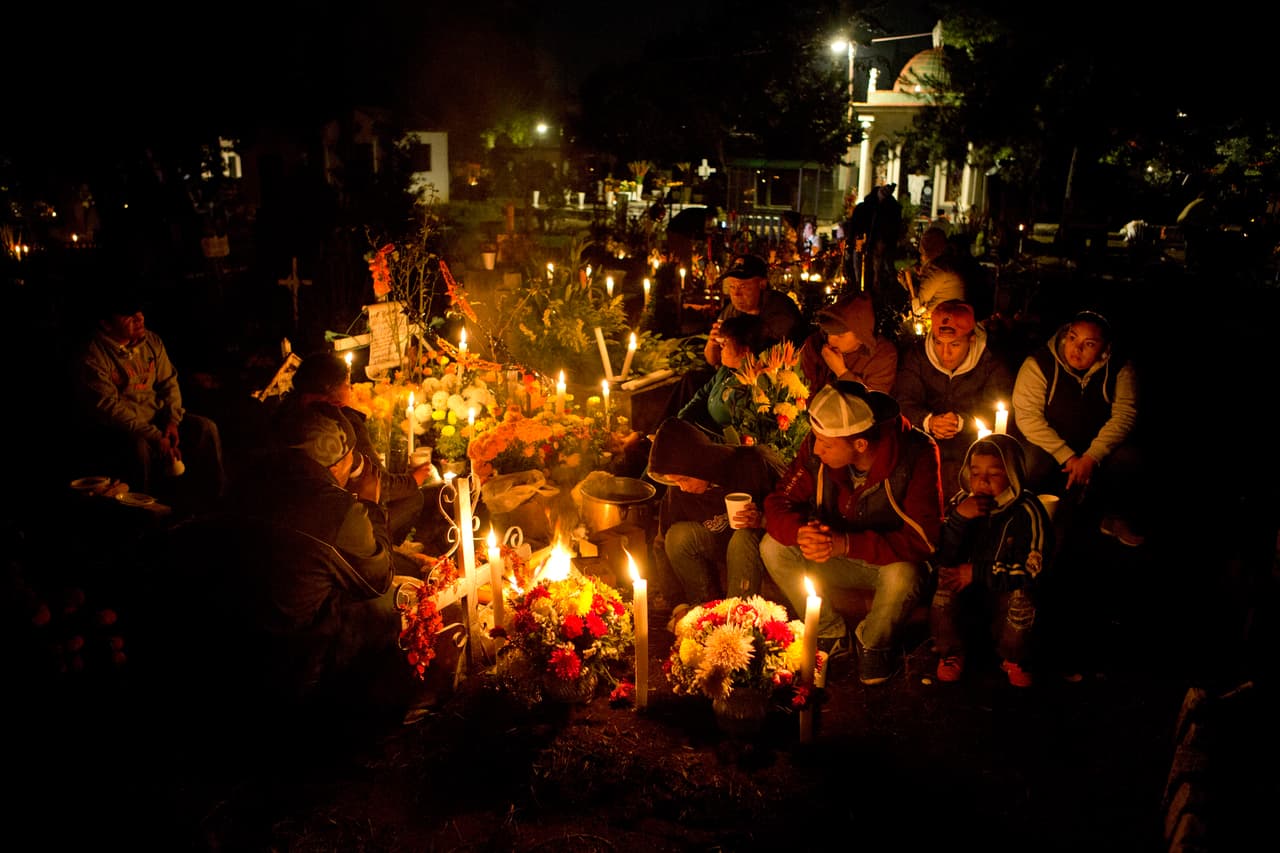 <b>México. </b>Una familia se reúne alrededor de la tumba de un pariente en el cementerio de San Gregorio, Ciudad de México. En este país el Día de Todos los Santos es una de las fechas más tradicionales. Los mexicanos visitan las sepulturas de sus seres queridos en todos los rincones del país.