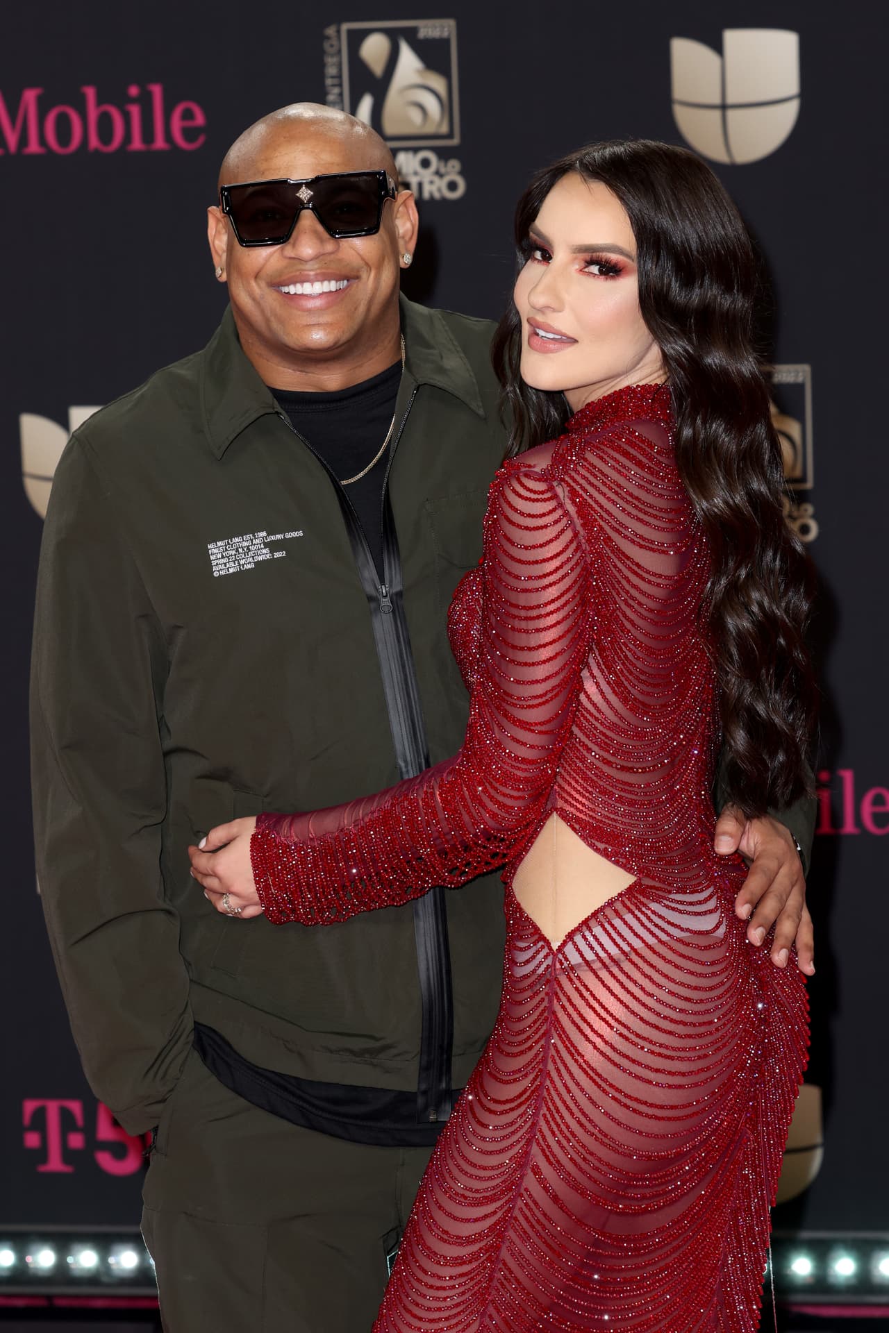 Mily se enfundó en un vestido largo color rojo con transparencias e hizo juego con un par de tacones plateados. Alexander, por su parte, eligió un conjunto color verde olivo y lentes oscuros.