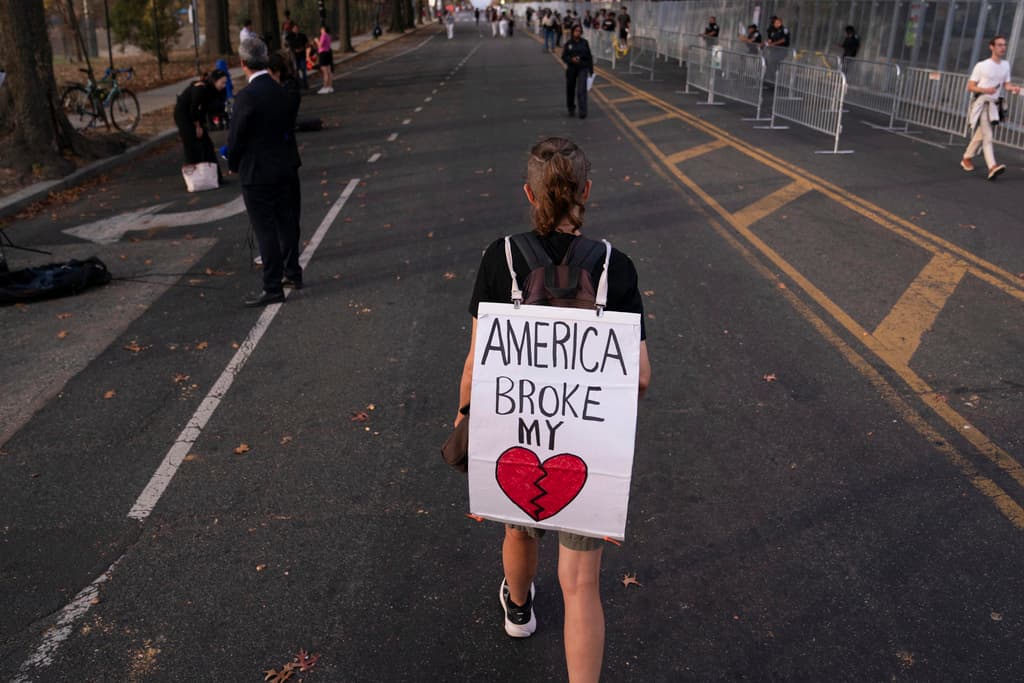 Robin Galbraith camina por una calle del campus de la Universidad Howard, donde la vicepresidenta Kamala Harris dio un discurso este miércoles para aceptar los resultados electorales. En la pancarta que pende sobre sus hombros se lee: "Estados Unidos rompió mi corazón".
