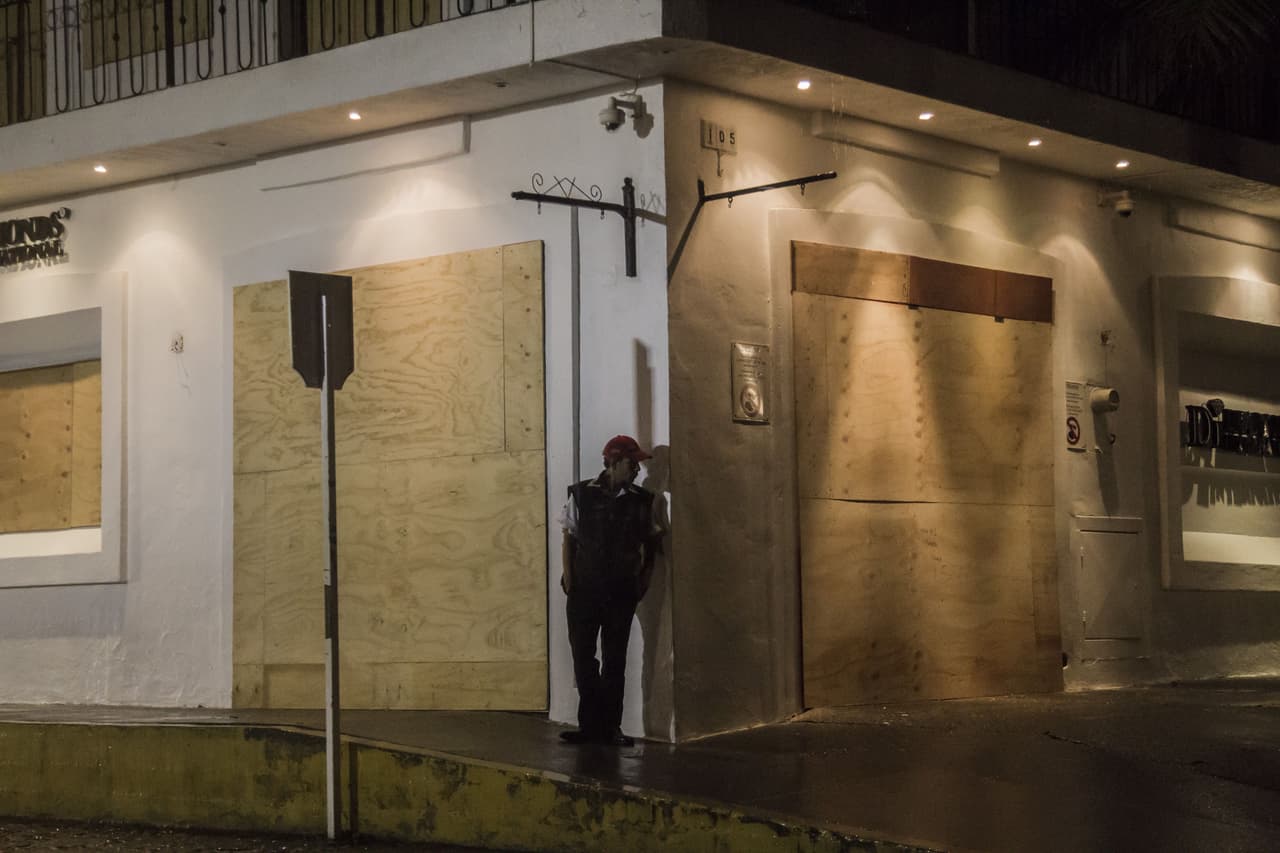 Un hombre se guarece de la lluvia que deja Patricia a su paso por México.