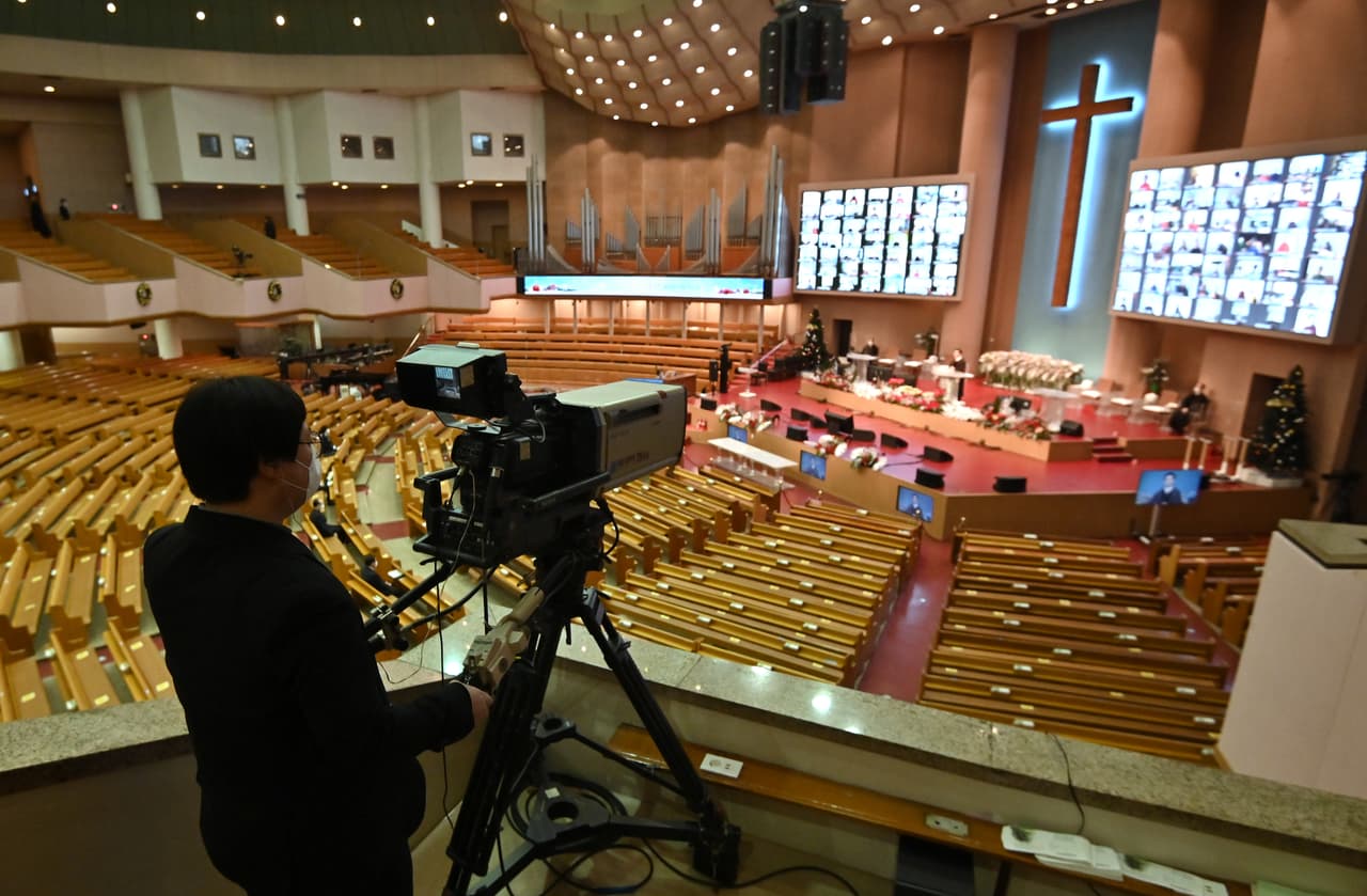 Un camarógrafo filma la iglesia vacía durante una misa navideña el 25 de diciembre del 2020 en Seúl, Corea del Sur.