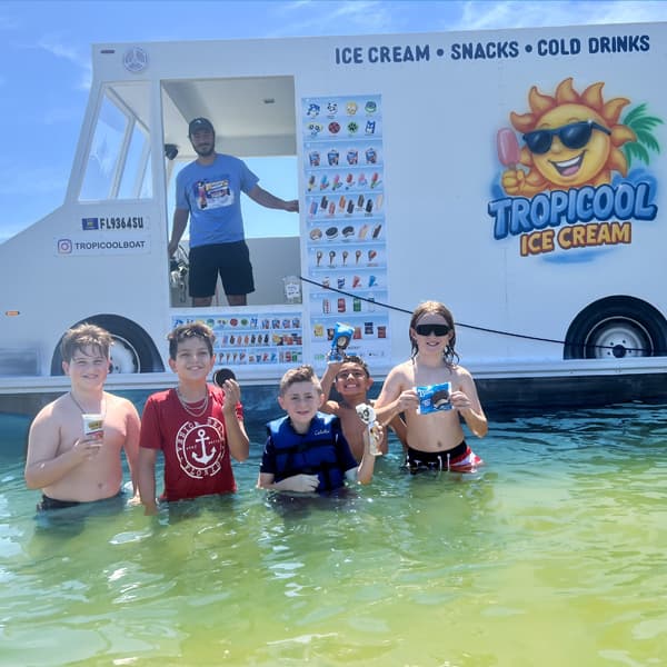 Niños y adultos disfrutan de los productos ofrecidos por Tropicool Ice Cream mientras pasan el día en el agua. La empresa ha ganado popularidad por acercar el servicio directamente a zonas recreativas.