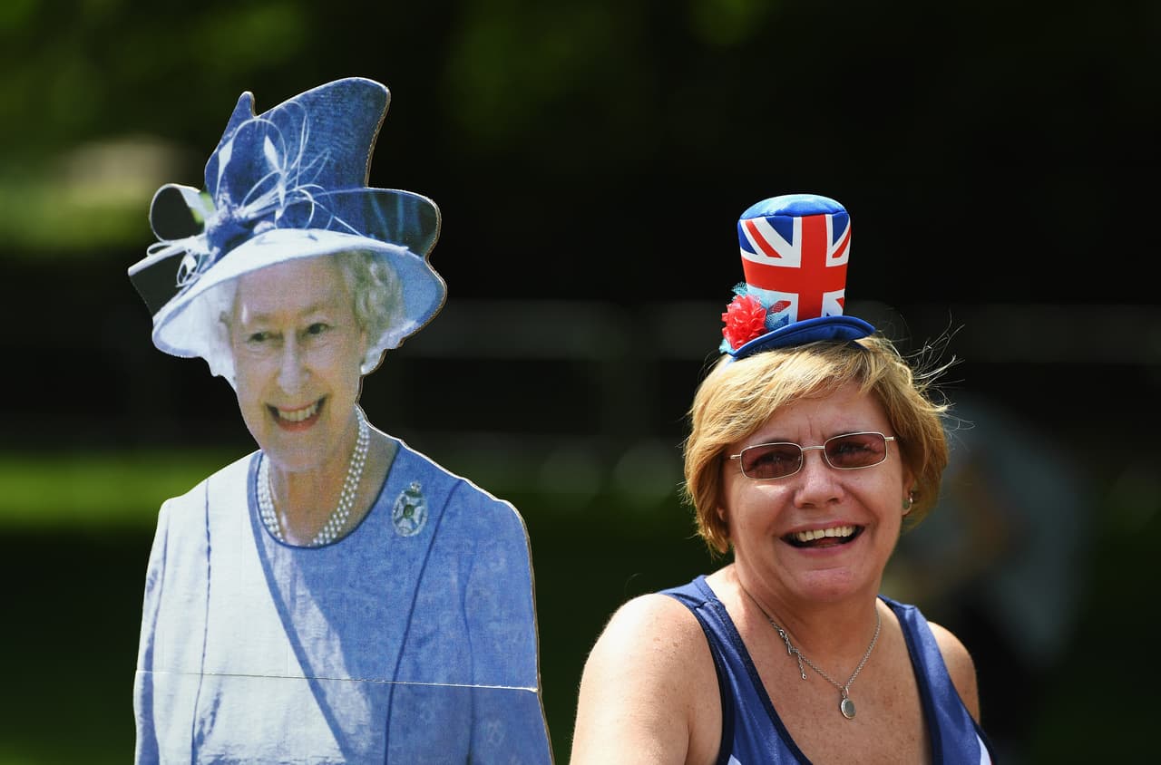 Entre los elementos más comentados en este tipo de evento están los sombreros. Esta ciudadana no quiso quedarse atrás y posó con la bandera en la cabeza y junto a una reina Isabel de cartón.