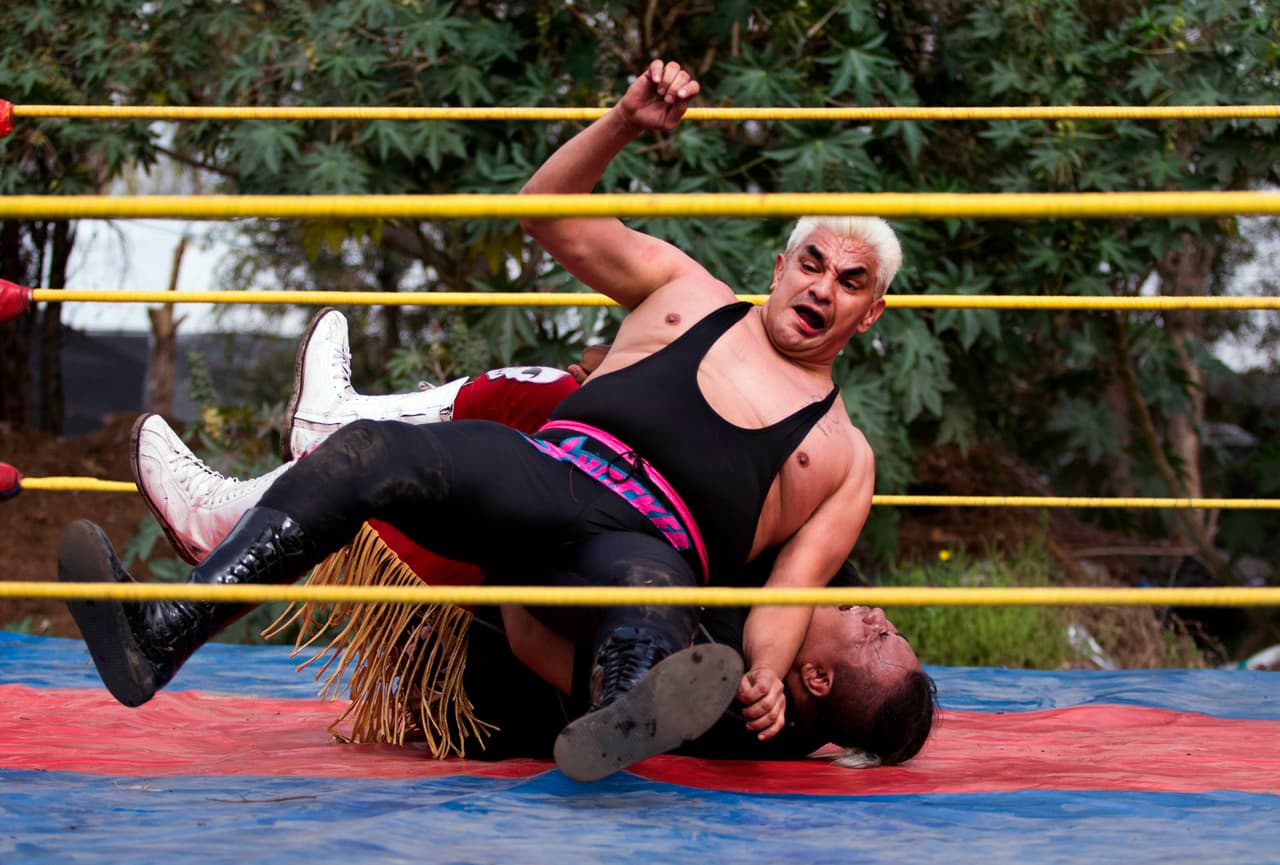 “¡Ay, qué bonito ring”!, suspira otro combatiente al ver el solitario encordado
<b>en medio de montículos de tierra, cultivos de hortalizas, plantas y macetas de plástico que algunos usaron como arma contra sus rivales. </b>
<br>
<br>El popular Shocker actúa durante su función en el evento, quien se dijo agradecido de participar ya que extrañaba luchar.