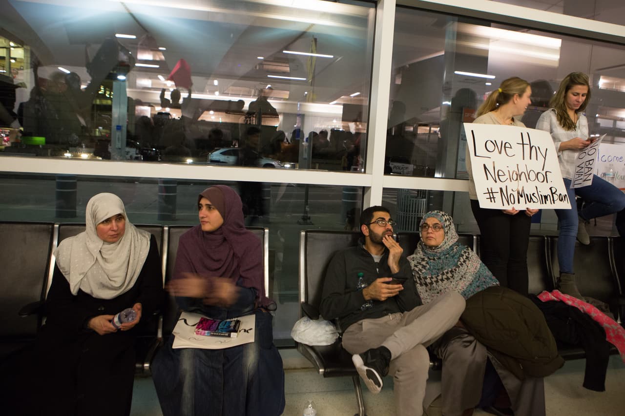 La escena en la sala de llegadas del aeropuerto de Dallas, Texas: "Ama a tu vecino, no a la prohibición de entrada a musulmanes".