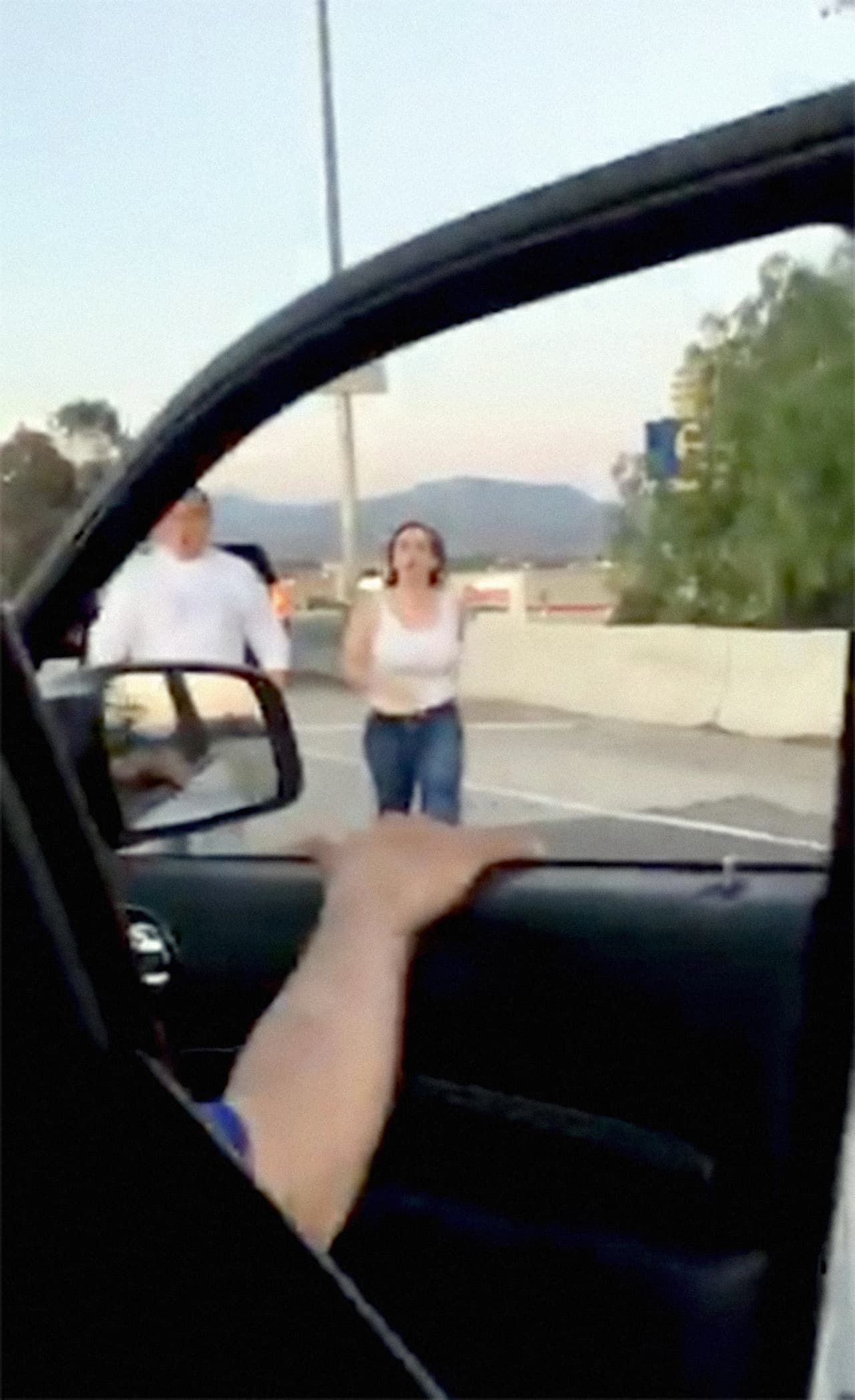 Una pareja bloquea con su camioneta a un auto en el que viajaba una familia hispana. Y camina hacia ellos para reclamarles.