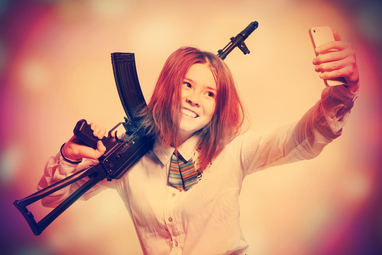 Girl with a Kalashnikov in his hand makes selfie