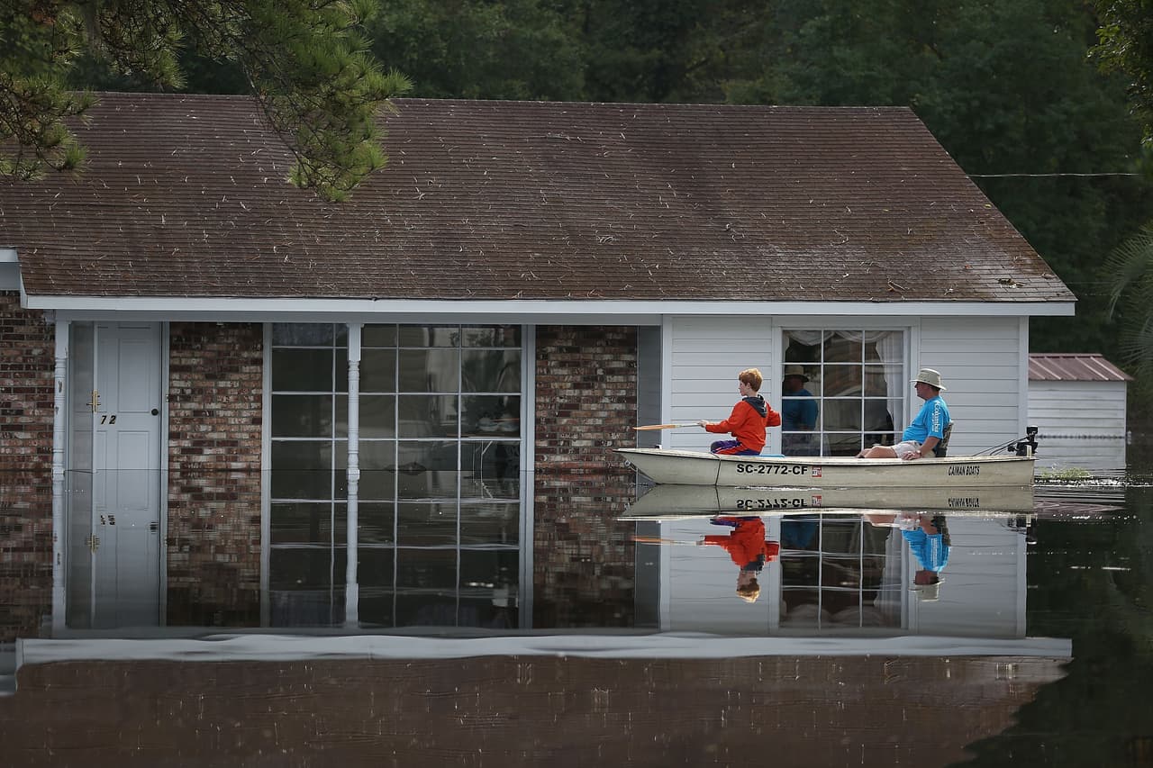 ANDREWS, SC - OCTOBER 09: Allen Poston and his nephew, Braxton Blakley, check on his mothers home that is inundated by flood water coming from the breached dams upstream as the water continues to reach areas in the eastern part of the state on October 9, 2015 in Andrews, South Carolina. The state of South Carolina experienced record rainfall amounts causing severe flooding and officials expect the damage from the flooding waters to be in the billions of dollars. (Photo by Joe Raedle/Getty Images)