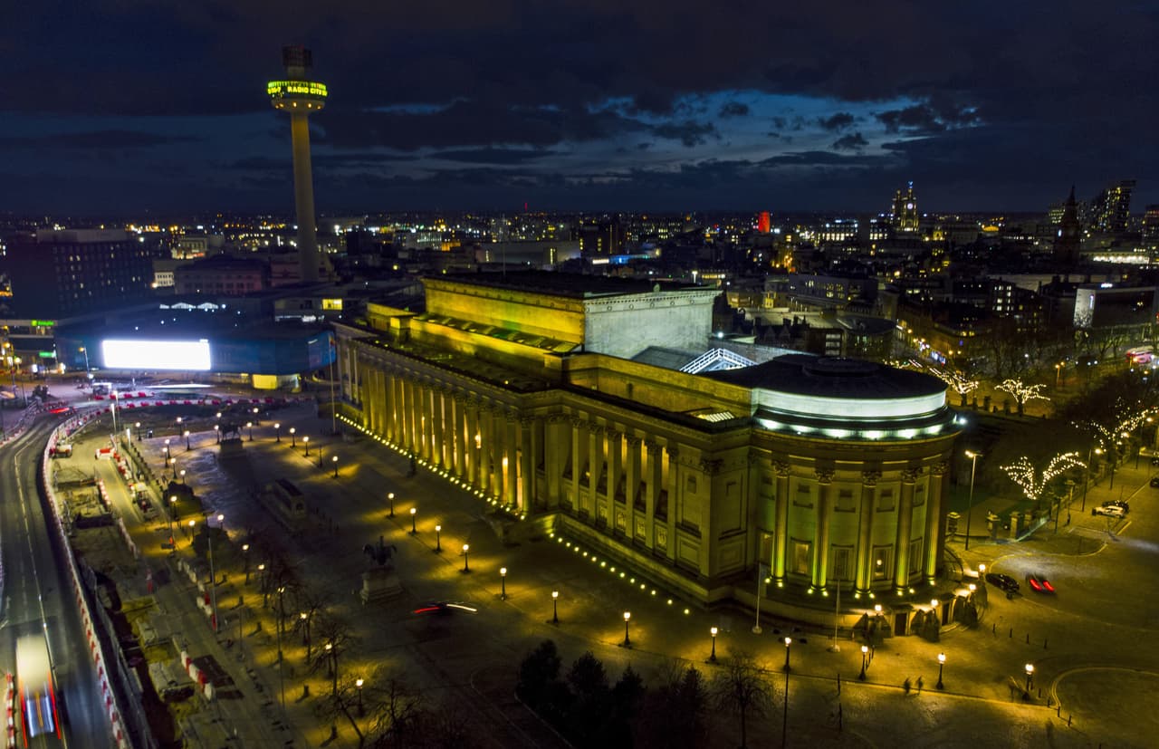 Johnson fue hospitalizado en cuidados intensivos con covid-19 a pocos días del comienzo del confinamiento y enfrentó críticas por retrasar el primer cierre. Italia había sido el primer país europeo en declarar cuarentenas a principios de marzo de 2020, seguido por la mayor parte del resto del continente. En la fotografía el edificio St Georges Hall de Liverpool, iluminado de amarillo.
<br>