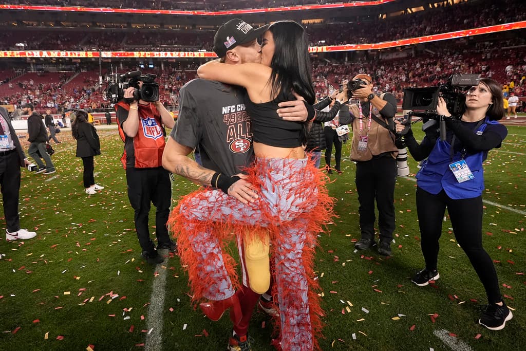 El ala cerrada de los 49ers de San Francisco, George Kittle, centro izquierda, celebra con su esposa, Claire, después del partido de fútbol americano de la NFL por el campeonato de la NFC contra los Lions de Detroit en Santa Clara, California, el domingo 28 de enero de 2024. (Foto AP/Mark J .terril)