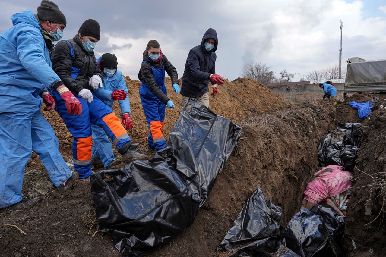 Un grupo de voluntarios coloca cadáveres en una fosa común a las afueras de Mariupol. La ONU reportó el martes 8 de marzo que 
<a href="https://www.univision.com/noticias/la-invasion-de-rusia-a-ucrania-en-numeros-cuantas-victimas-deja-y-que-cantidad-de-civiles-han-tenido-que-huir-video" target="_blank">había confirmado 474 muertos</a> desde el inicio de la invasión rusa a Ucrania, pero ha subrayado que teme que la cifra sea mucho mayor. La información desde 
<b>Mariupol</b> es complicada debido al asedio ruso. La mayoría de las vías de comunicación no funcionan, y solo aquellos con acceso a teléfonos satelitales han podido informar sobre el desarrollo de los combates en la ciudad portuaria, según un reporte de 
<i>The New York Times</i>.