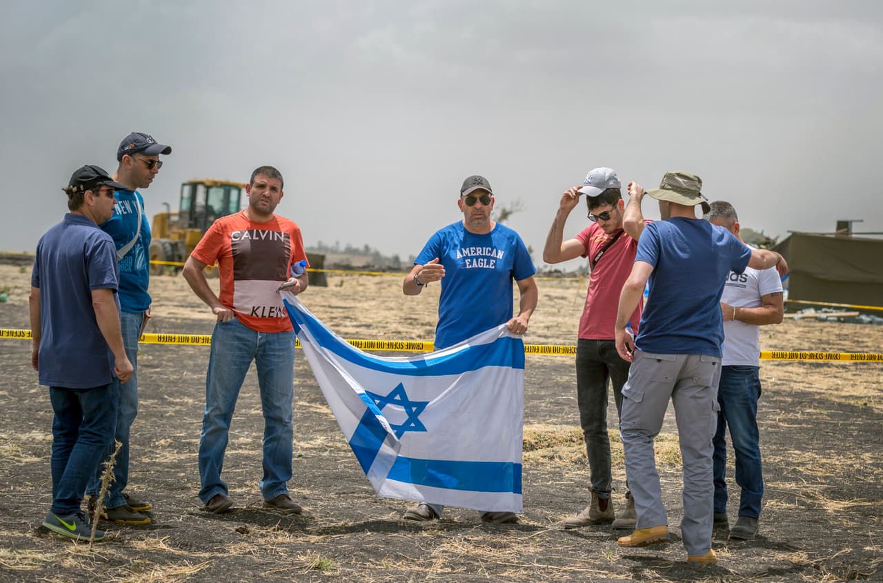 Parientes israelíes sostienen su bandera en la escena.