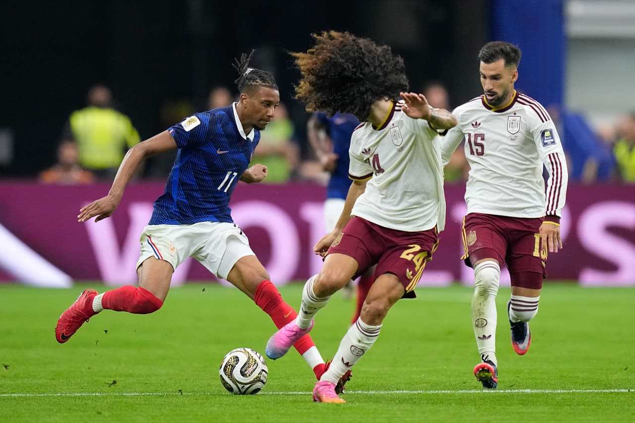 El francés Michael Olise (izquierda) disputa el balón con los españoles Marc Cucurella y Alex Baena (derecha) durante el partido de semifinales de la Copa del Mundo entre Francia y España en Arlington, Texas, cerca de Dallas, el martes 14 de julio de 2026.