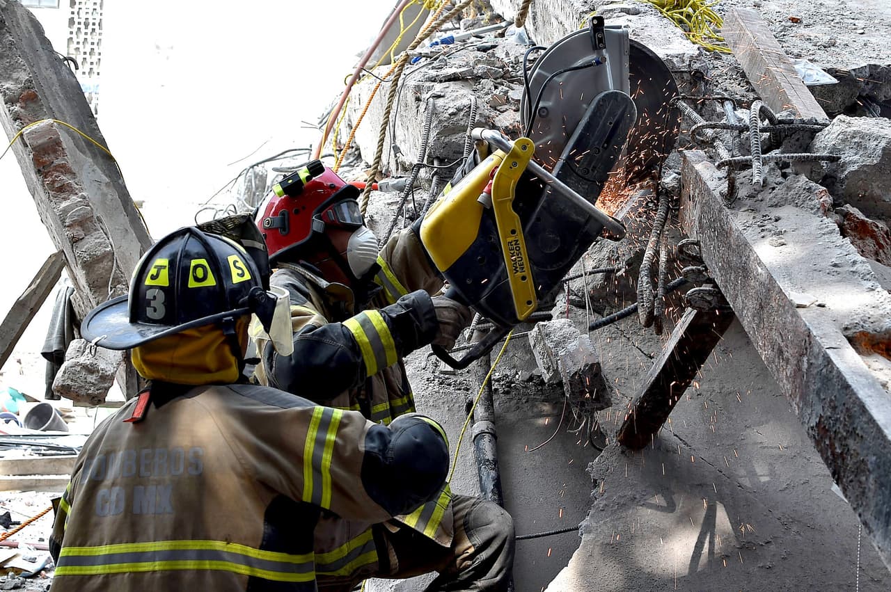 Firefighters cut concrete steel bars to clear the rubble on the site where a multistory building was flattened by a 7.1-magnitude quake on the eve searching for survivors, in Mexico City, on September 20, 2019. Rescuers frantically searched Wednesday for survivors of a powerful earthquake that killed more than 200 people in Mexico on the anniversary of another massive quake that left thousands dead and still haunts the country. / AFP PHOTO / YURI CORTEZ (Photo credit should read YURI CORTEZ/AFP/Getty Images)