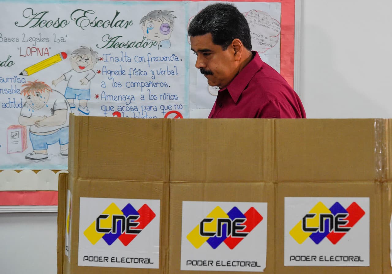 Venezuelan President Nicolas Maduro casts his vote during the presidential elections in Caracas on May 20, 2018 - Venezuelans, reeling under a devastating economic crisis, began voting Sunday in an election boycotted by the opposition and condemned by much of the international community but expected to hand deeply unpopular President Nicolas Maduro a new mandate (Photo by Juan BARRETO / AFP) (Photo credit should read JUAN BARRETO/AFP/Getty Images)