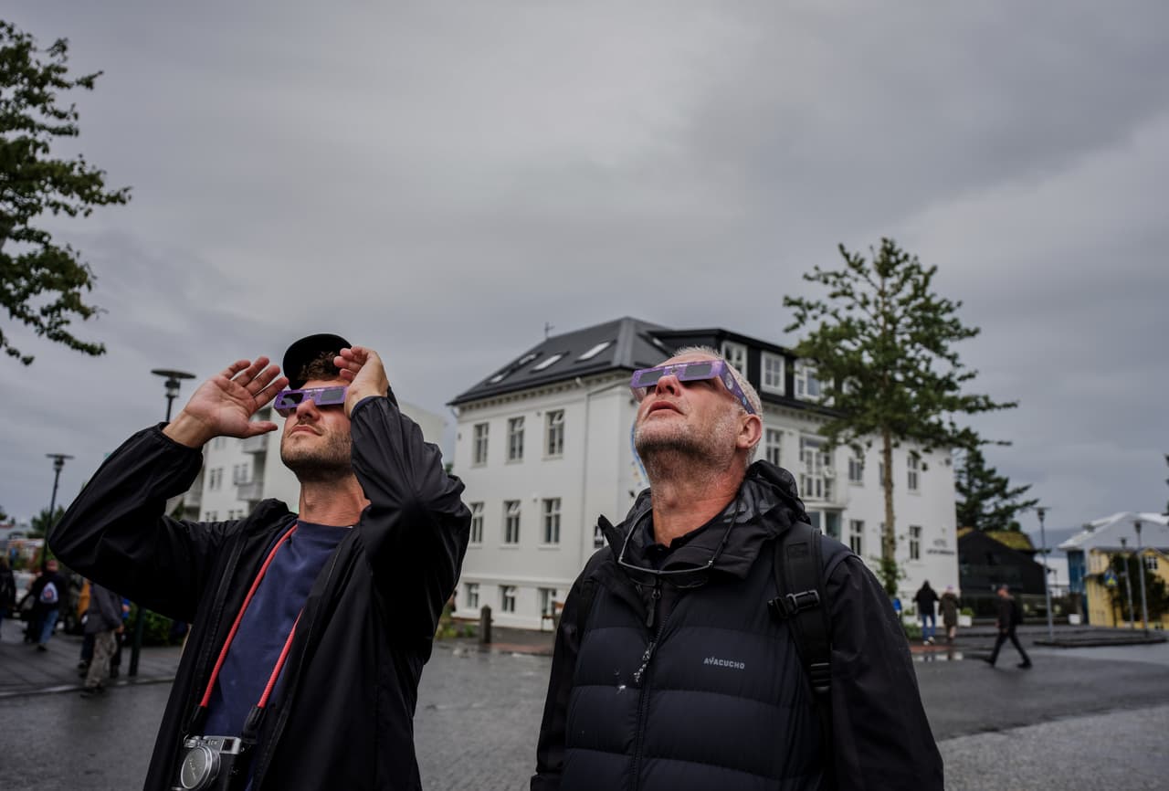 Personas usan gafas especiales para eclipses solares para mirar al sol antes de un eclipse solar en Reikiavik, Islandia, el miércoles 12 de agosto de 2026.