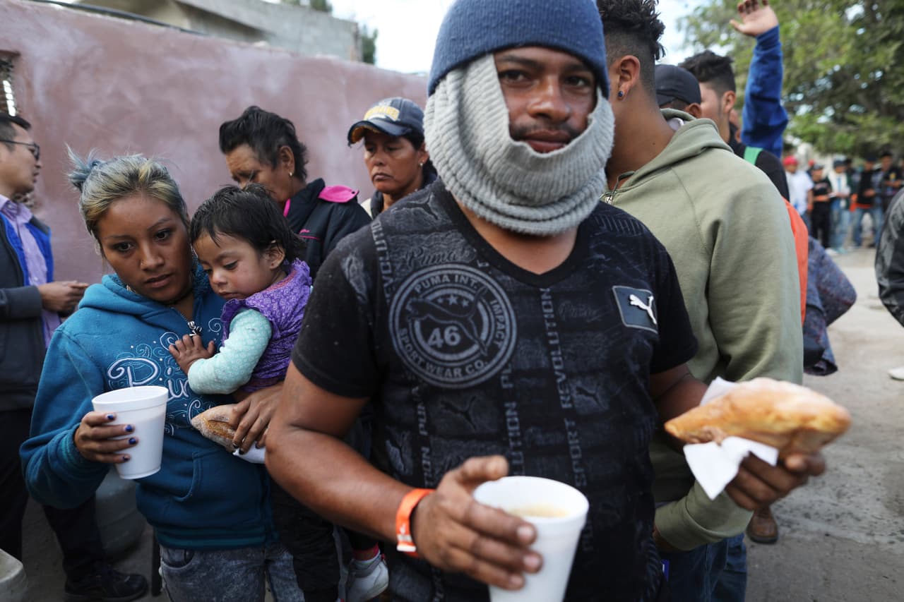 Un grupo de migrantes desayunando frente a uno de los refugios de Tijuana.