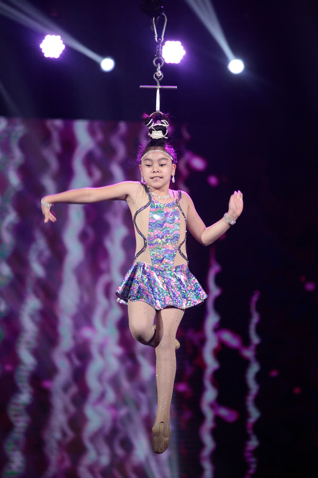 Su función se complementa con un gancho del que sostiene su pelo. Entonces empieza a ascender. Sí, solamente ayudada de su pelo.