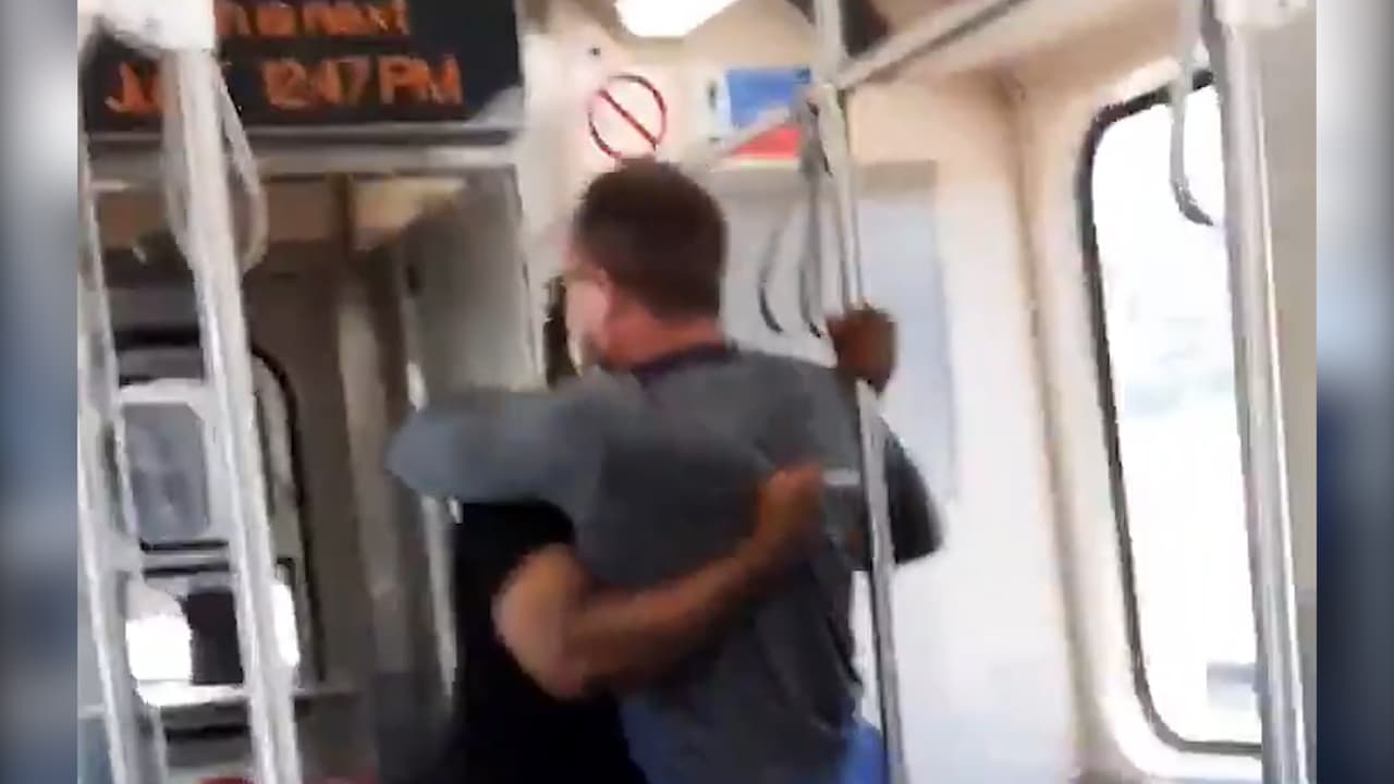 Un enfermero forcejea con un hombre que lo acusa a él y sus colegas por la pandemia