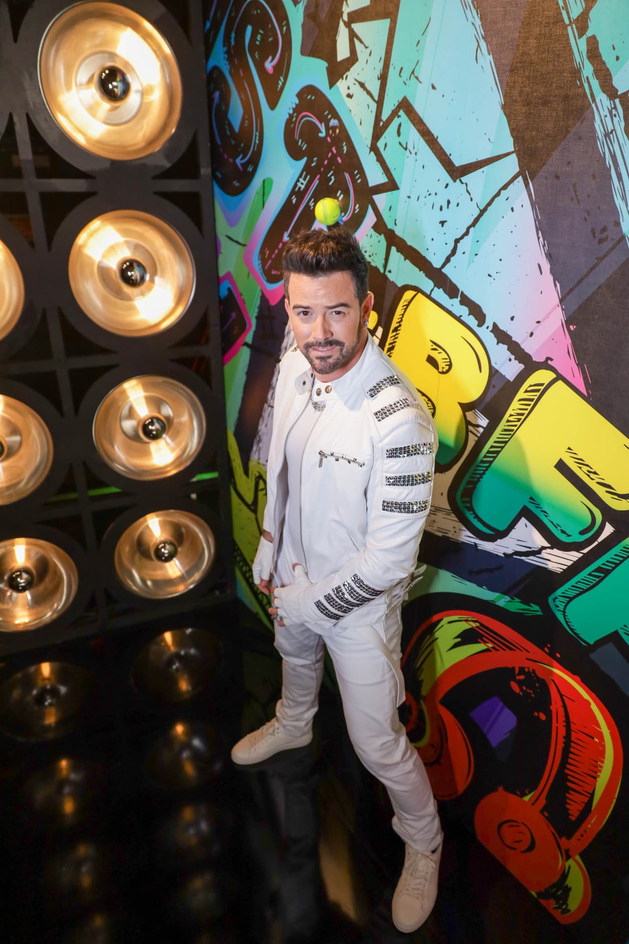 En el reto de Ellas vs Ellos, el conductor se vistió de forma adecuada para bailar 'Everybody' de los Backstreet Boys junto a los participantes: con jeans, chamarra de piel, playera, guantes y zapatos deportivos; todo el conjunto completamente blanco.