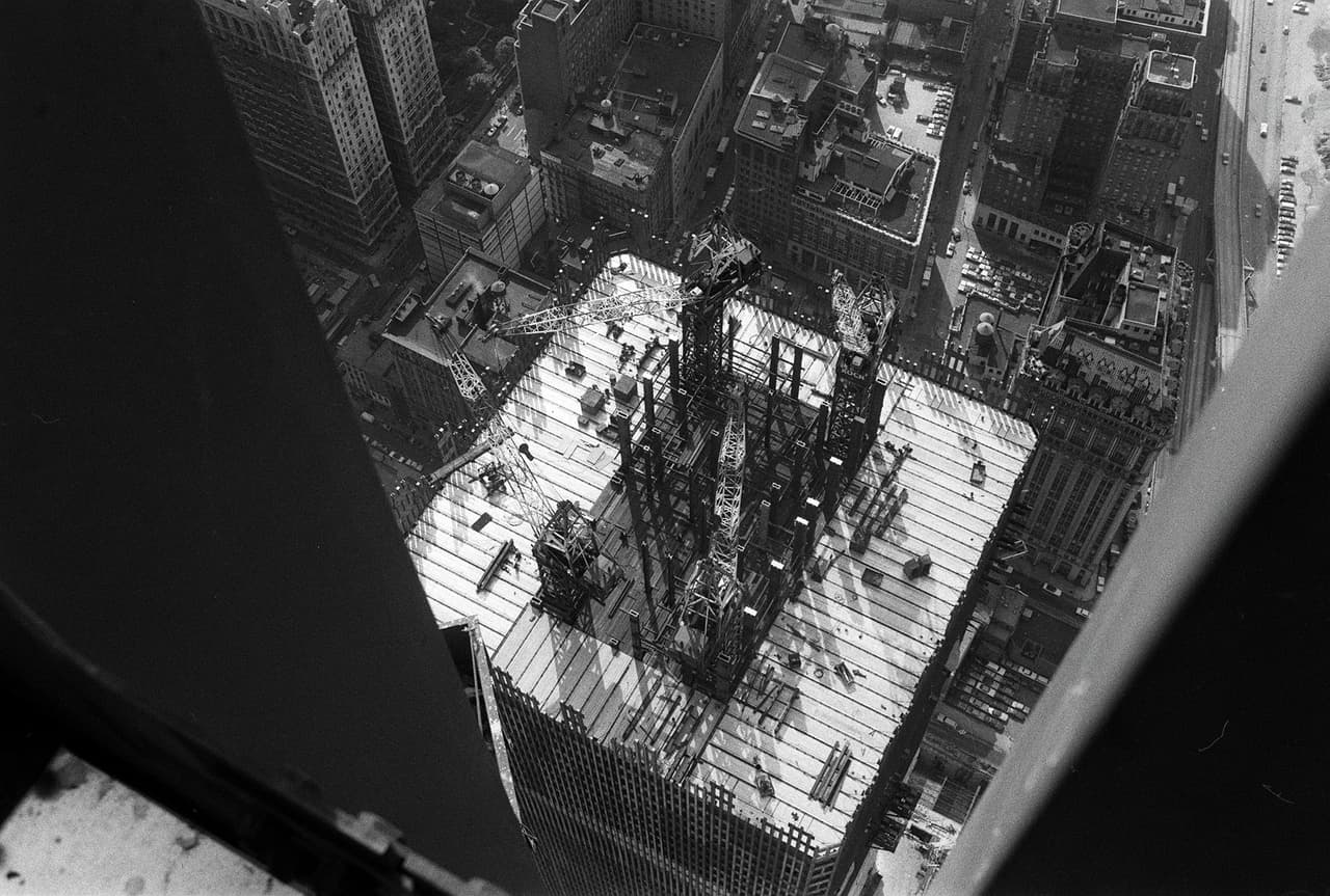 Esta fotografía de la torre norte en construcción en 1970 muestra el innovador diseño. Se agruparon las columnas de soporte de acero en el centro de la estructura, una manera de maximizar la cantidad de espacio abierto en cada piso. El sostén del edificio se completaba con la capa externa, una piel de acero que además daba el dibujo del exterior. 
<br>
<br>
<a href="https://www.history.com/topics/landmarks/world-trade-center"><u>El complejo World Trade Center constaba de siete edificios y fue construido entre 1966 y 1973</u></a>. Costó unos 470 millones de dólares (más de 4,000 millones en dólares de hoy) y tenía capacidad para 50,000 trabajadores y 200,000 visitantes diarios en 10 millones de pies cuadrados de espacio.